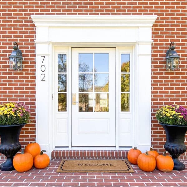 pumpkins by a white front door