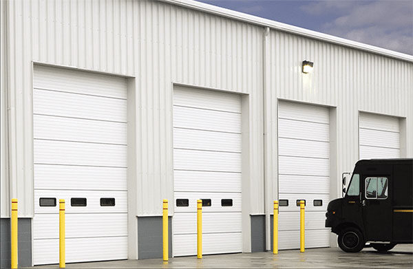 4 commercial garage doors in warehouse with black delivery truck